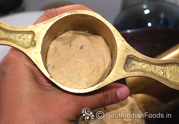 Put 1 handful dough in a murukku kuzhal