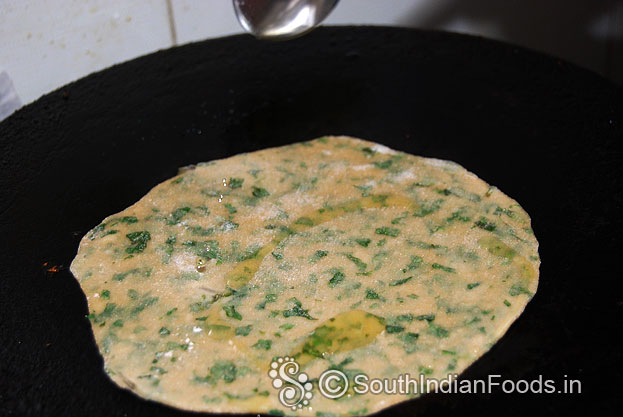 Heat iron dosa tawa, place prepared raw pudina roti, pour one tbsp oil, cook till soft and golden brown