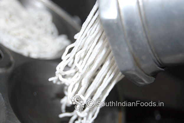 Put dough[one handful] in idiyappam kuzhal squeeze over idli plates