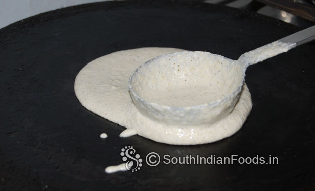 Heat iron dosa tawa, pour 1 laddle of batter, spread it[clockwise round shape]