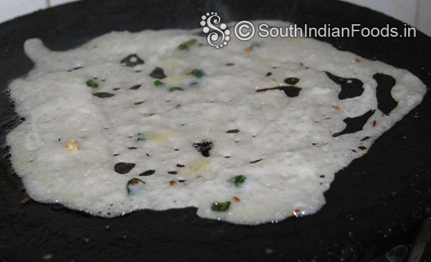 Pour rava dosa batter over the iron dosa tawa then drizzle oil