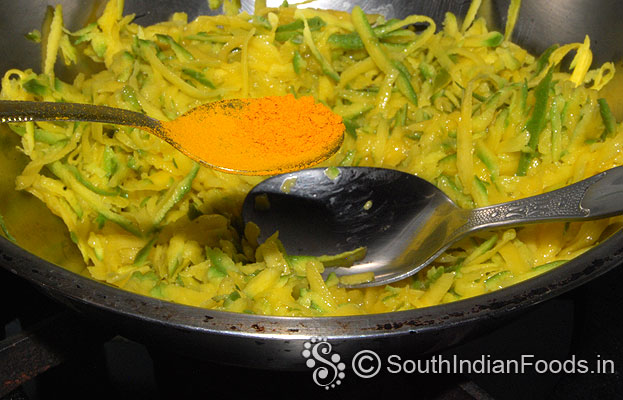 Heat pan add grated mango, turmeric powder
