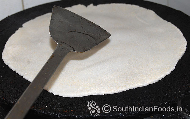 Heat dosa tawa, place raw rice roti, add 1 tbsp oil around the roti