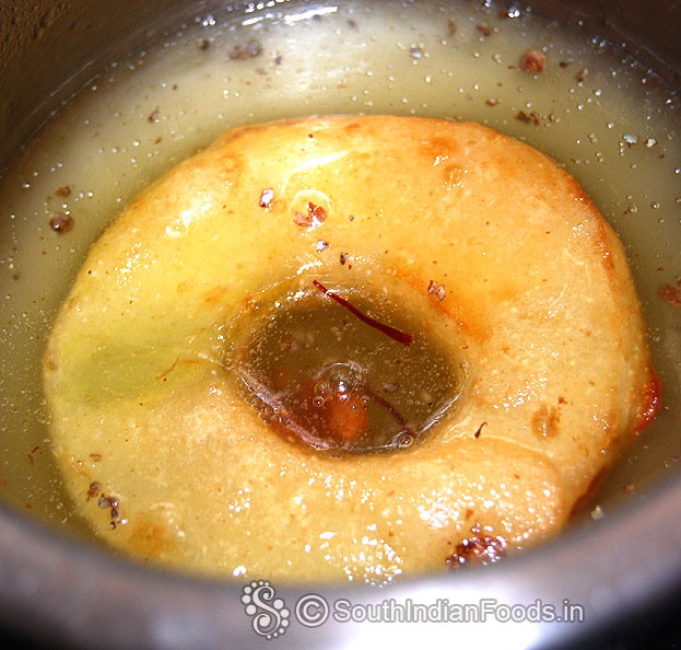 Soak prepared apple fritters in sugar syrup for 2 min then take it out