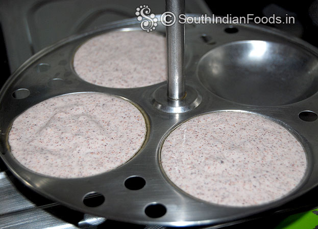 Grease idli plate with sesame oil, pour batter