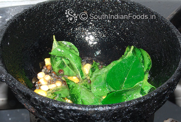 For seasoning heat oil in a iron laddle, add bengal gram, urad dal & curry leaves