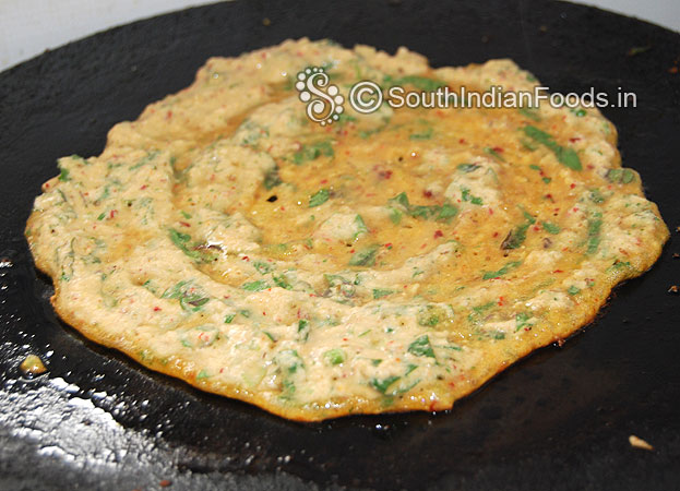 Heat iron dosa tawa, pour 1 ladle of batter, spread immediately, pour oil over the adai