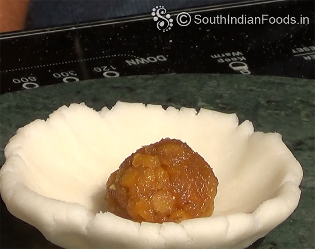 Add chana dal jaggery stuffing, close the edges, make ball shape again