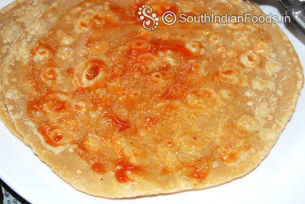 Take one chapathi, place 1 tbsp tomato chilli sauce, spread evenly