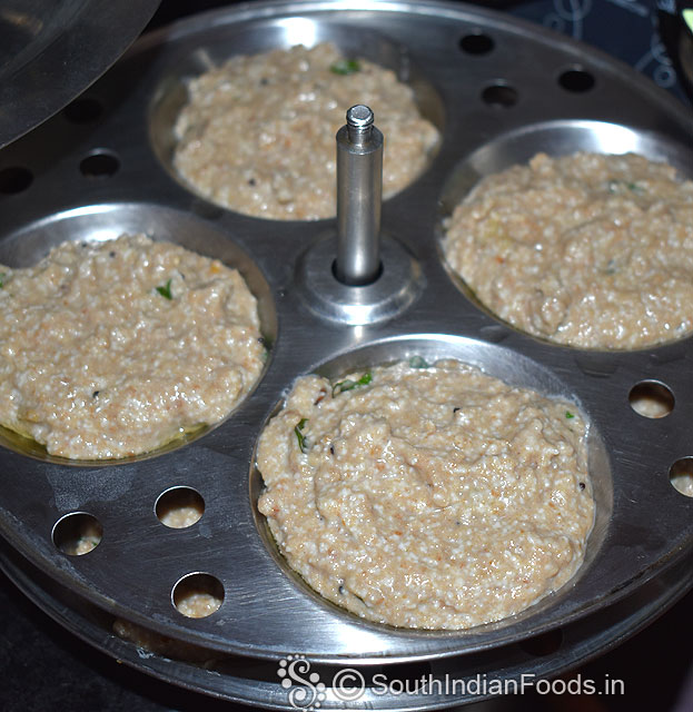 Grease idli batter with sesame oil, pour batter