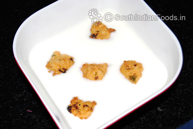 Take a bowl with curd then add sugar, salt mix well & add vada 
