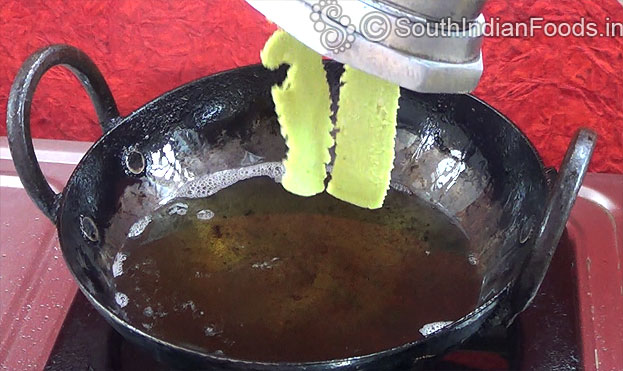 Put handful dough into murukku kuzhal, squeeze over the oil