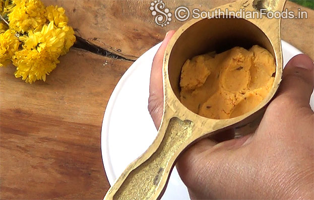 Add 1 handful dough into the murukku kuzhal