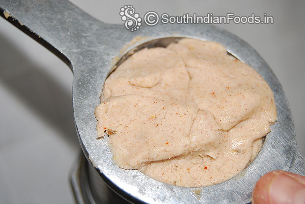 Place one handful of dough in to the murukku kuzhal & press out
